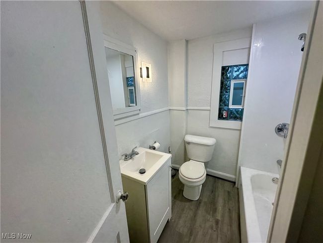 Full bath with a washtub, wood finished floors, vanity, and toilet | Image 17
