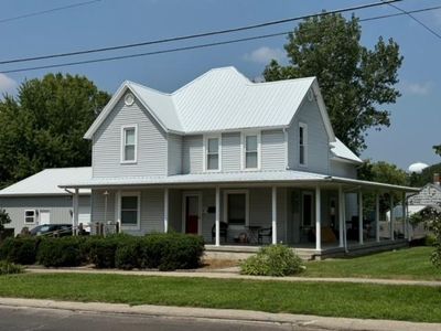 Farmhouse-style home featuring a front lawn and covered porch | Image 2