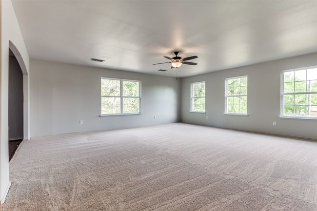 Empty room featuring a ceiling fan, carpet, and arched walkways | Image 31