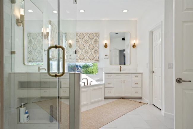Full bath with a shower stall, tile patterned floors, recessed lighting, vanity, and a tub to relax in | Image 15