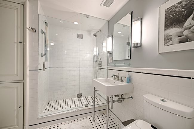 Hall bath featuring a stall shower, tile walls, a wainscoted wall, and recessed lighting | Image 18