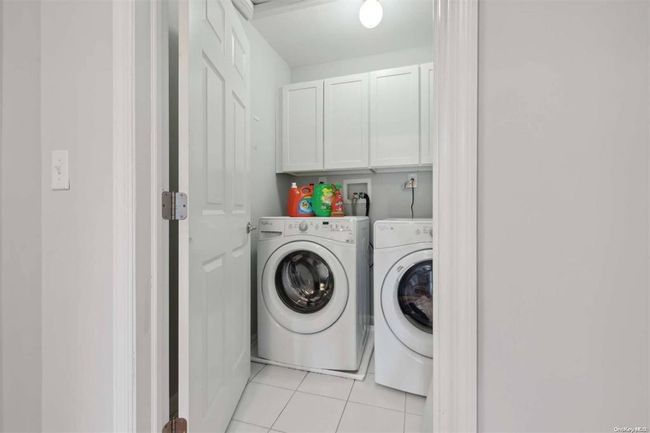 Laundry room with independent washer and dryer, cabinet space, and light tile patterned flooring | Image 17
