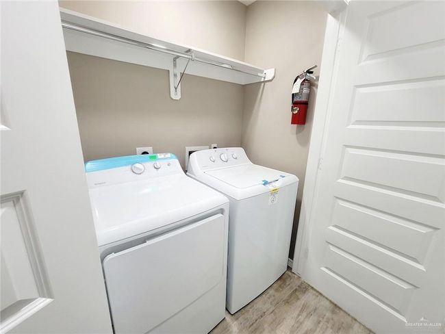 Washroom with separate washer and dryer and light wood-style flooring | Image 12