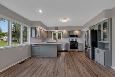 Enjoy the natural light, big window over the kitchen sink, and new stainless steel appliances in this updated kitchen. | Image 3