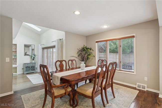 Dining space featuring dark wood-style flooring, visible vents, a wealth of natural light, and baseboards | Image 14