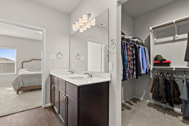 Bathroom featuring double vanity, ensuite bath, baseboards, and a spacious closet | Image 20