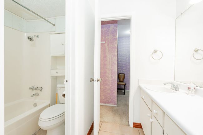 Full bathroom with tile patterned flooring, toilet, vanity, shower / bath combination, and baseboards | Image 11