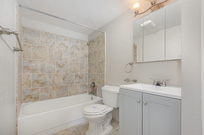 Full bathroom featuring bathing tub / shower combination, vanity, and tile patterned floors | Image 16