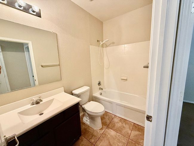 Full bathroom featuring washtub / shower combination, vanity, and tile patterned flooring | Image 16