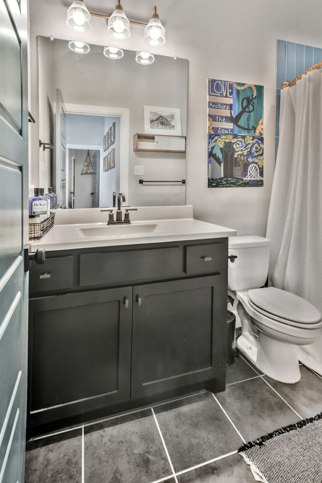 Bathroom with vanity, a shower with shower curtain, and tile patterned floors | Image 24