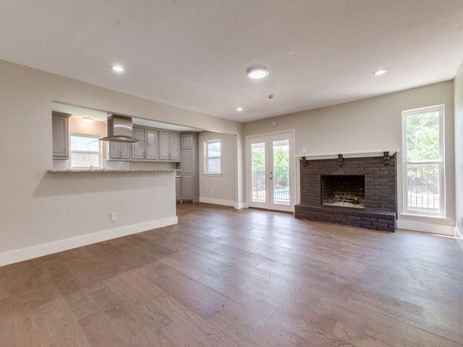 Unfurnished living room featuring a fireplace, wood finished floors, baseboards, and recessed lighting | Image 5