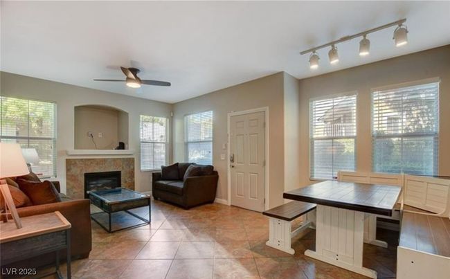 Living area with tile patterned floors, a wealth of natural light, ceiling fan, and a tiled​​‌​​​​‌​​‌‌​‌‌​​​‌‌​​‌‌​‌​​​​​‌ fireplace | Image 9