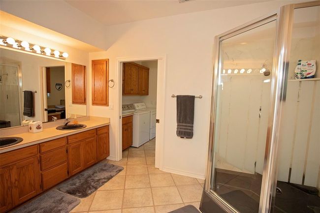 Clothes washing area with cabinets, sink, washing machine and dryer, and light tile floors | Image 29