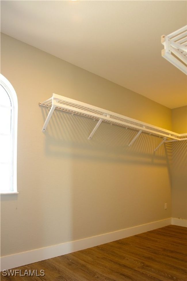 Walk in closet featuring dark wood-style flooring | Image 6