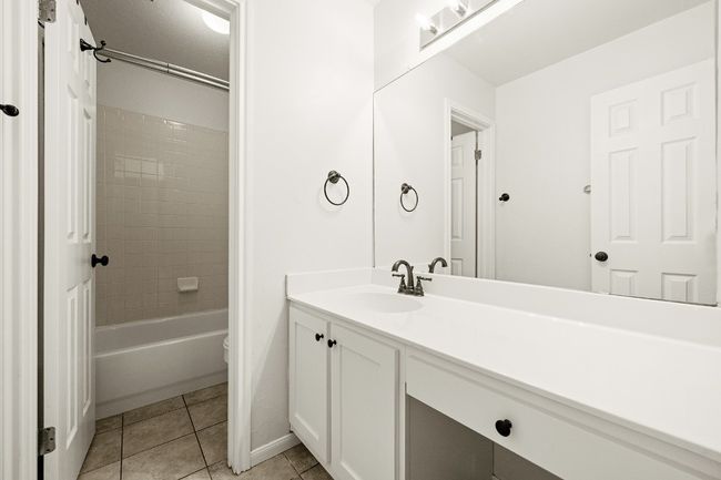 Full bathroom featuring vanity, washtub / shower combination, and tile patterned flooring | Image 13