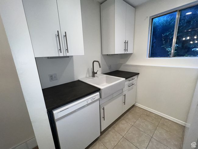 Kitchen with dishwasher, white cabinets, a sink, and light tile patterned floors | Image 6