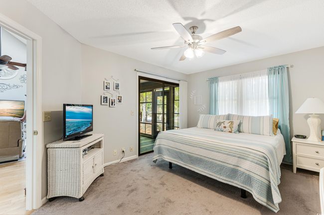 Bedroom featuring ceiling fan, access to outside, light colored carpet, and baseboards | Image 12