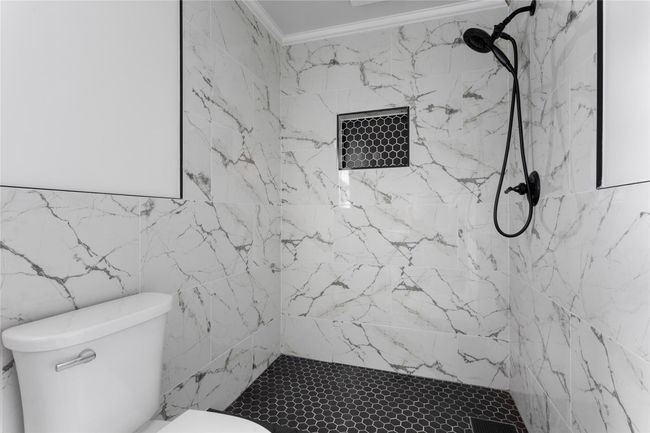 Bathroom with toilet and a marble finish shower | Image 6