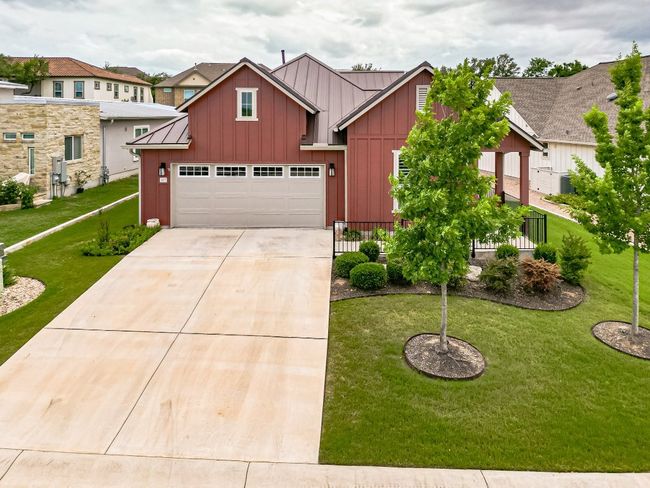 View of front facade featuring board and batten siding, driveway, and a front lawn | Image 37