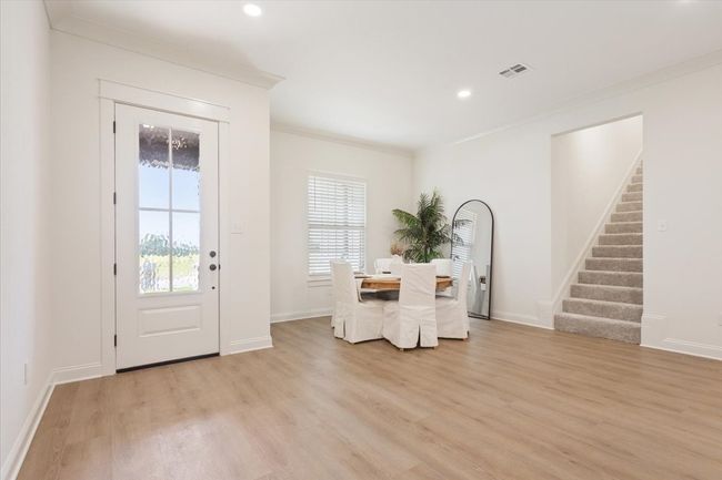 Dining room featuring crown molding, light wood finished floors, stairway, and recessed lighting | Image 5