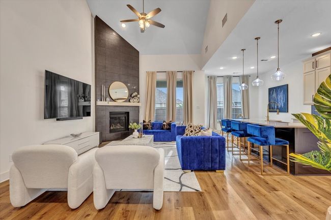 This classy, open-concept family room has plenty of natural light and blends into an open kitchen for all your friends and family to gather in. Notice the beautiful fireplace with tiles from floor to ceiling as your focal point. This room says: "Let's gather!" | Image 10