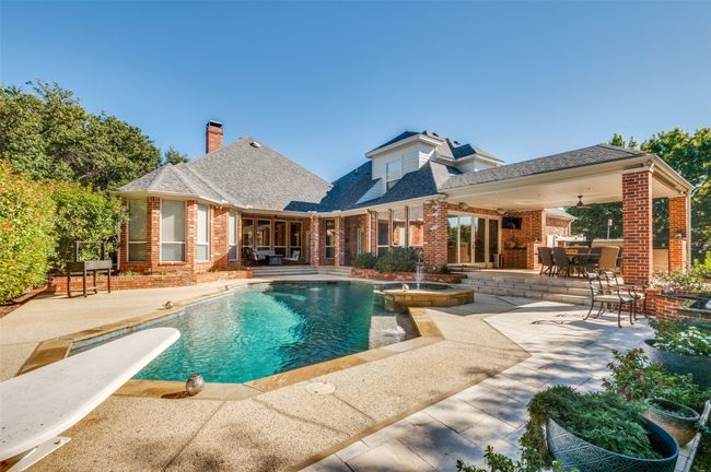 View of swimming pool with a patio area, a pool with connected hot tub, outdoor dining space, and a diving board | Image 31