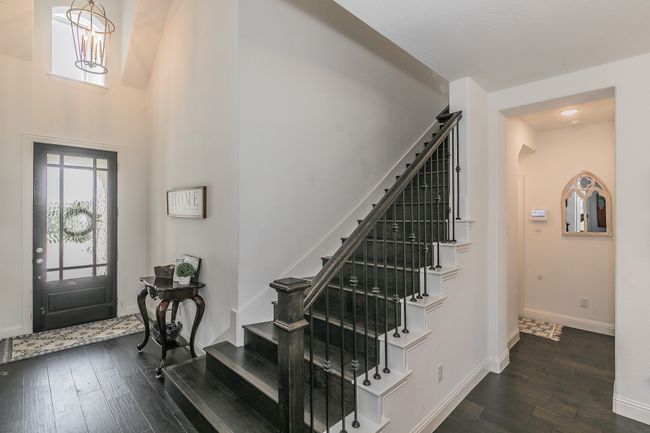 Entryway with stairway, dark wood-style floors, and a towering ceiling | Image 14