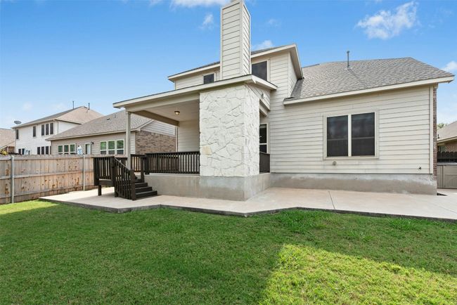 Gorgeous outdoor fireplace on raised cement deck. Private yard. Extended cement patio around back and sides of home. | Image 28