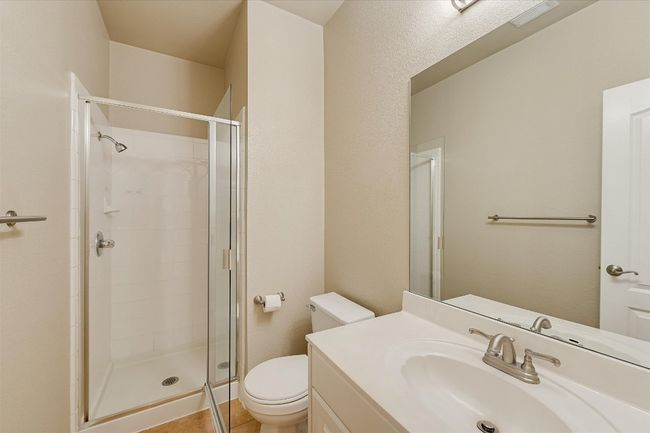 Bathroom featuring a shower stall, vanity, and tile patterned flooring | Image 17