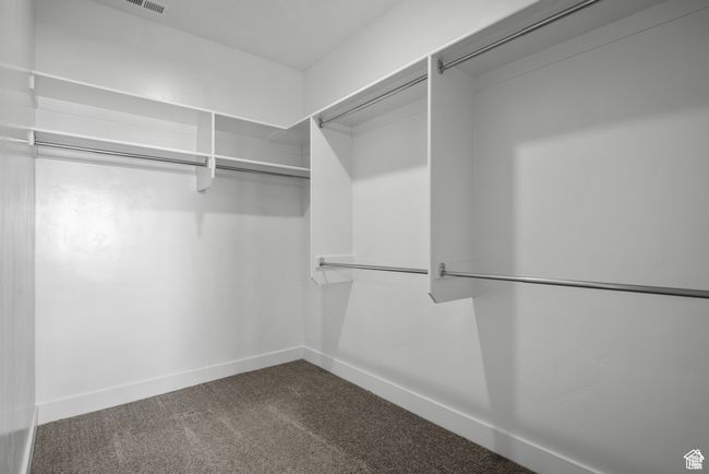 Spacious closet featuring dark colored carpet | Image 18