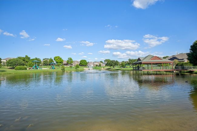 Community pond with covered outdoor space and playground. Walking trail around park area. | Image 34