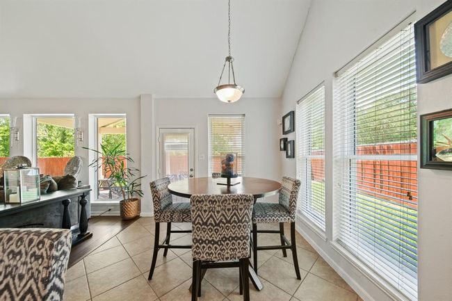Surrounded by windows, this cheerful dining area is filled with natural light and offers tranquil views of the backyard. | Image 17
