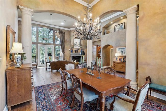 Three 11' cast-stone columns define the dining room, illuminated beneath the glimmer of the custom-made wrought iron chandelier and wall sconces. The rich, antique wood floors flow throughout the common areas of the first level, salvaged from a tobacco barn and finished with European Hard Oil. They were installed on a concrete slab that was prepared with a tar sealant which acts as a moisture barrier, a screed to provide a smooth, level surface and plywood as a stable base on which to attach the wood. | Image 8