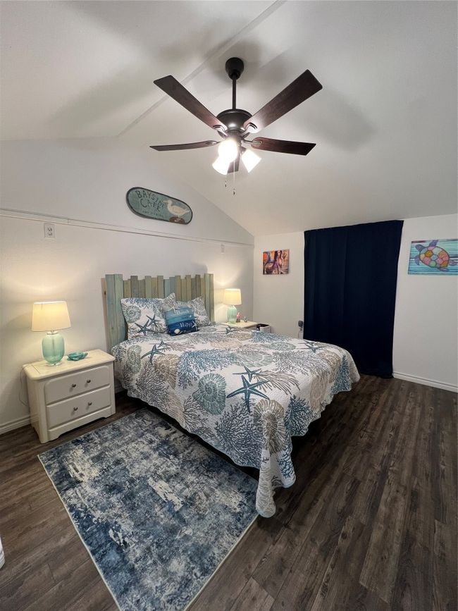 Bedroom featuring baseboards, lofted ceiling, ceiling fan, and wood finished floors | Image 22