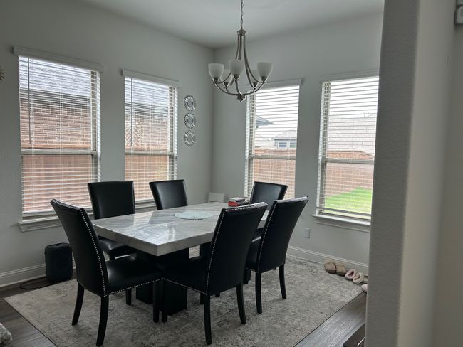 Dining area featuring an inviting chandelier, baseboards, and wood finished floors | Image 8