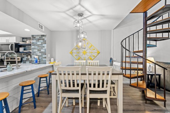 Dining space featuring wood finished floors, stairs, and recessed lighting | Image 8