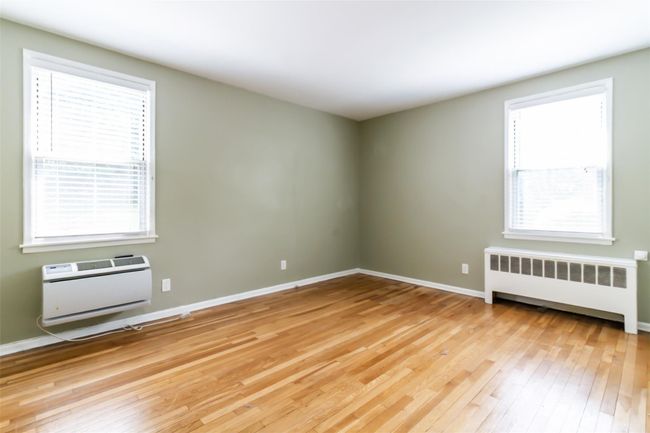 Primary bedroom with 2 exposures, hardwood floors, and a wall mounted AC | Image 5