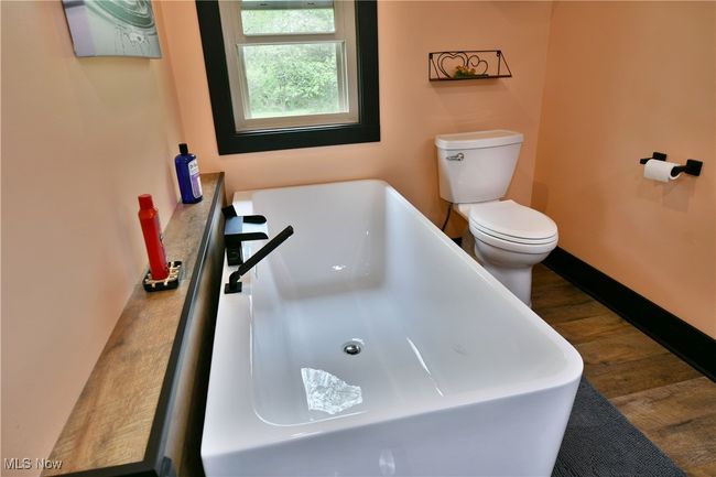 Full bathroom with wood finished floors, toilet, and a bathtub | Image 31