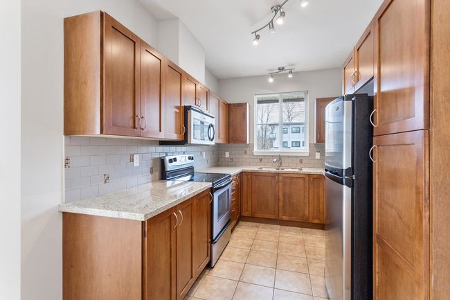 Kitchen with stainless steel appliances, granite countertops , wood cabinetry plus a bonus window. | Image 5