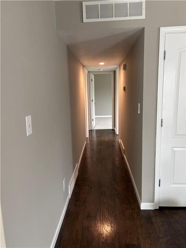 Hall featuring dark wood-style floors, visible vents, and baseboards | Image 13
