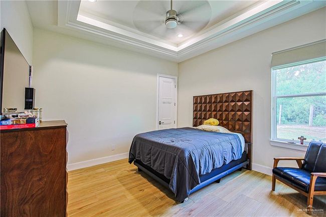 Bedroom featuring a raised ceiling, porcelain flooring, recessed lighting, and ceiling fan | Image 30