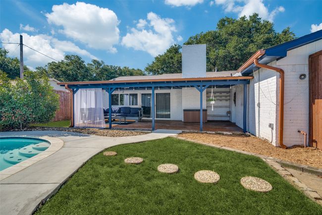 Rear view of property featuring a patio, brick siding, a chimney, an outdoor pool, and outdoor lounge area | Image 18