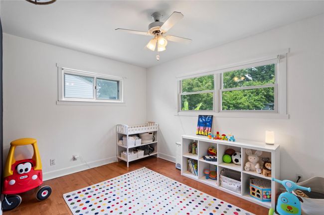 Bedroom with a baseboard heating unit, vaulted ceiling, access to outside, hardwood / wood-style floors, and an AC wall unit | Image 20