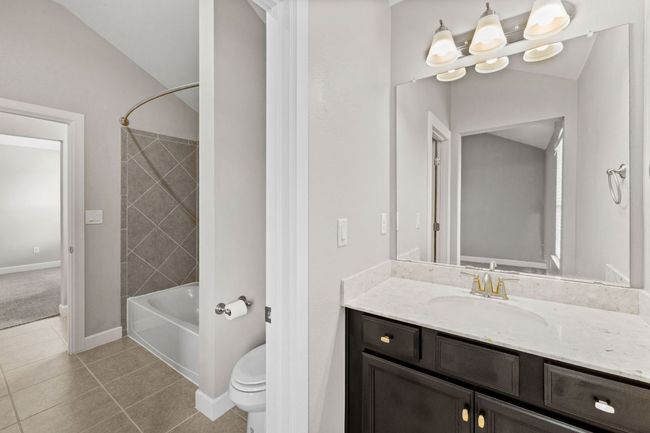 Full bath featuring baseboards, toilet, shower / bath combination, vanity, and tile patterned flooring | Image 30