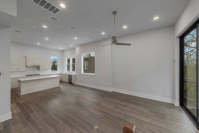 Unfurnished living room with a ceiling fan, visible vents, recessed lighting, and dark wood-type flooring | Image 10