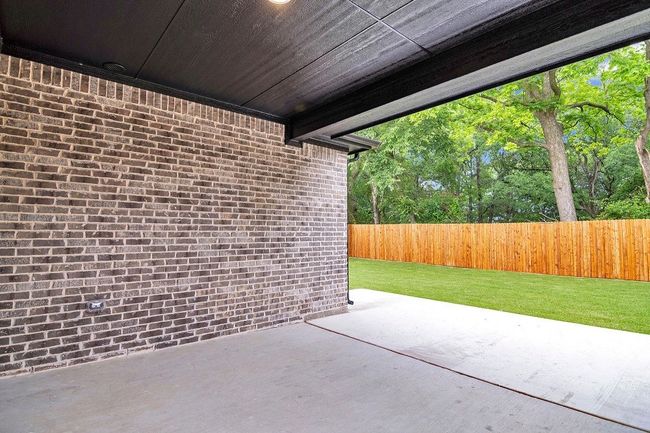 Fenced backyard with a patio | Image 25