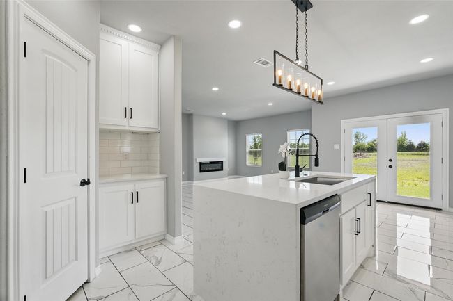 Kitchen featuring tile finish floor, stainless steel dishwasher, a sink, and recessed lighting | Image 7