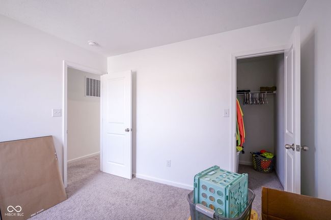 bedroom featuring carpet floors, a spacious closet, and a closet | Image 27