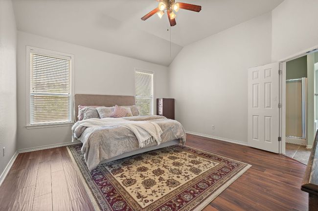 Bedroom featuring lofted ceiling, dark wood-style floors, baseboards, and a ceiling fan | Image 16