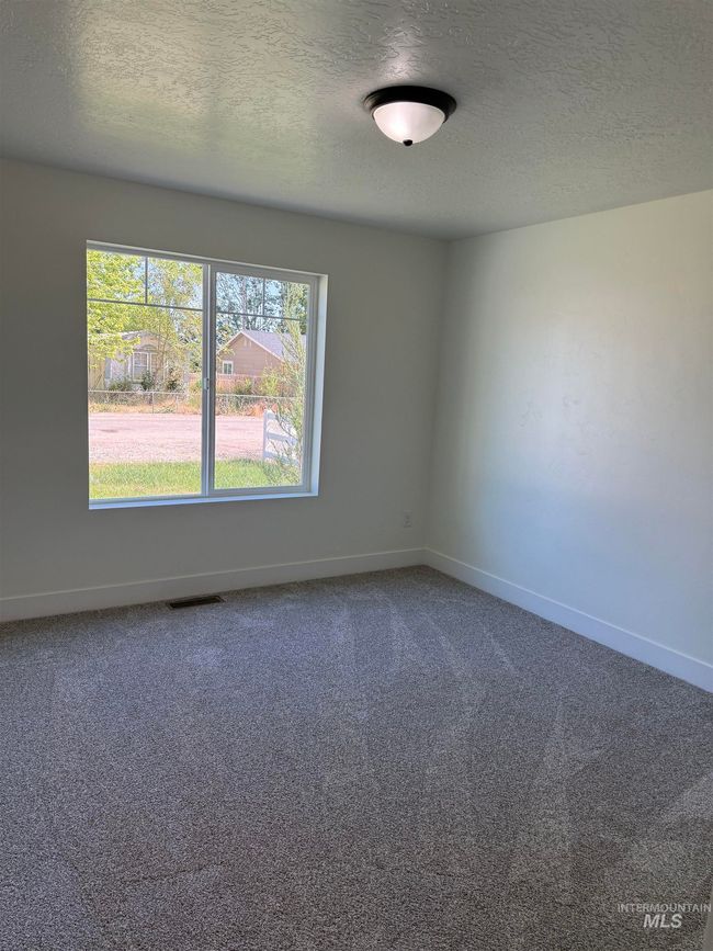 Empty room featuring a textured ceiling and carpet floors | Image 7